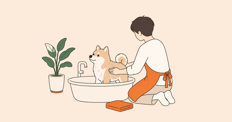 浴槽に入った柴犬の雑種を、オレンジのエプロンを着た人が後ろ姿で洗っているイラスト。そばに緑の鉢植えとオレンジのタオル